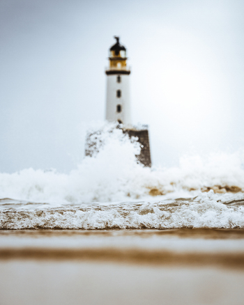 View of a majestic lighthouse amidst dynamic waves and a tranquil ocean Crimond Fraserburgh Great Britain.