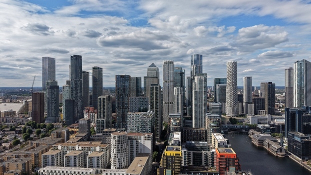 London United Kingdom 16 June 2026 Aerial view of Canary Wharf skyscrapers and modern residential towers under a cloudy sky.