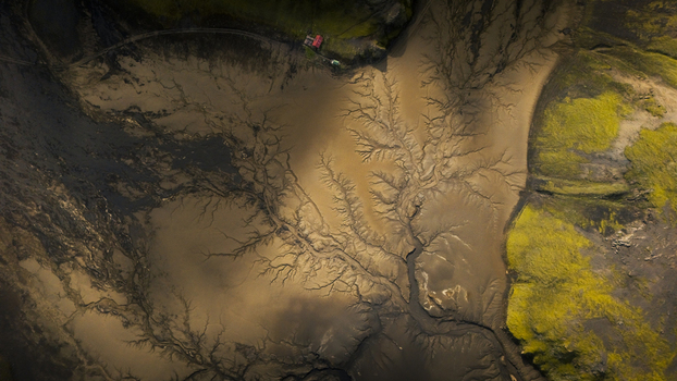 Aerial view of intricate branching patterns of a glacial river delta flowing through mossy green terrain in Vik Myrdalshreppur Iceland. Aerial view of intricate branching patterns of a glacial river delta flowing through mossy green terrain in Vik Myrdalshreppur Iceland.
