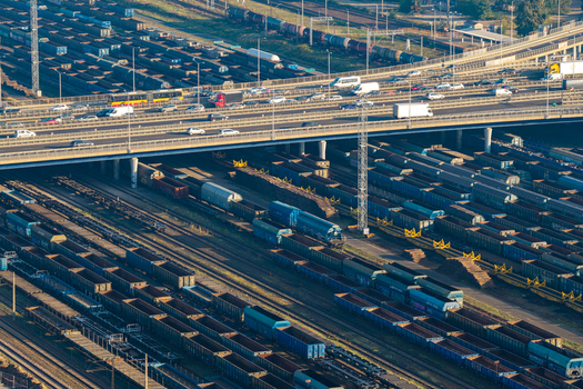 Warsaw Poland 14 September 2026 Aerial view of a large railway shipping hub featuring numerous freight train cars on parallel tracks beneath a busy highway overpass.