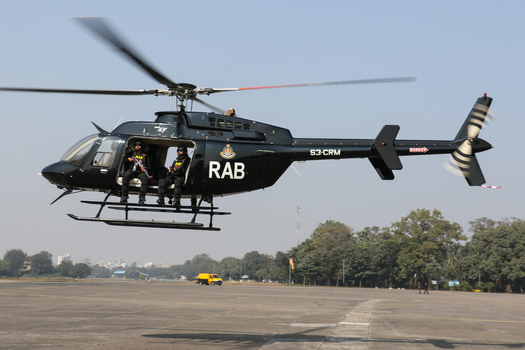 Dhaka Bangladesh 19 January 2017 View of a black RAB helicopter with spinning rotors and uniformed personnel inside at the RAB Headquarters. Dhaka Bangladesh 19 January 2017 View of a black RAB helicopter with spinning rotors and uniformed personnel inside at the RAB Headquarters.