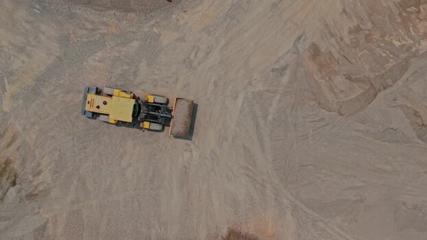 Aerial view of yellow bulldozer in a quarry Indonesia.