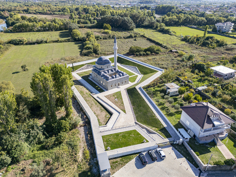 Aerial view of the Lead Mosque featuring its historic dome and minaret surrounded by landscaped gardens and stone pathways in the rural outskirts of Shkoder Shkoder County Albania. Aerial view of the Lead Mosque featuring its historic dome and minaret surrounded by landscaped gardens and stone pathways in the rural outskirts of Shkoder Shkoder County Albania.