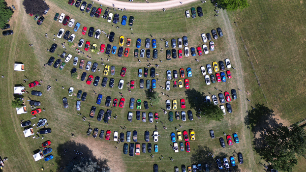 Francheleins France 04 June 2023 Aerial view of a car show at Chateau de Vataneins with rows of colorful vehicles parked on the grass and people walking around. Francheleins France 04 June 2023 Aerial view of a car show at Chateau de Vataneins with rows of colorful vehicles parked on the grass and people walking around.