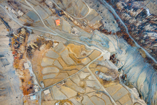 Aerial view of a tapestry of earthy tones and textures where terraced fields meet winding paths revealing the stark beauty of Chapursan Valley Hunza Nagar Pakistan. Aerial view of a tapestry of earthy tones and textures where terraced fields meet winding paths revealing the stark beauty of Chapursan Valley Hunza Nagar Pakistan.