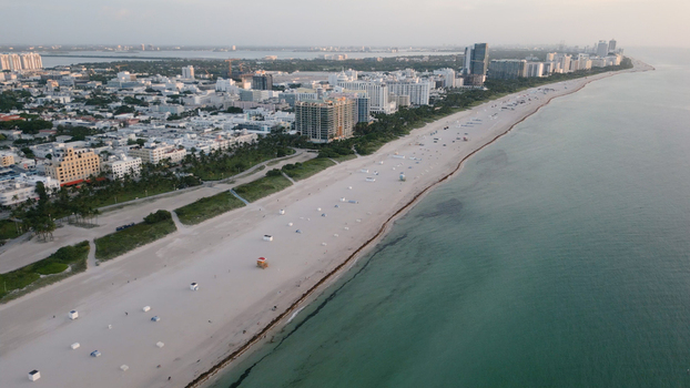 Aerial view of the sandy coastline and iconic hotels along the shore of Miami Beach Florida United States. Aerial view of the sandy coastline and iconic hotels along the shore of Miami Beach Florida United States.