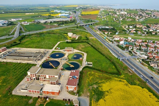 Aerial view of a water treatment plant with circular sedimentation tanks surrounded by green fields and a highway in Silivri Istanbul Turkey. Aerial view of a water treatment plant with circular sedimentation tanks surrounded by green fields and a highway in Silivri Istanbul Turkey.