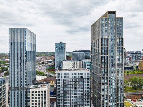 Aerial view of modern high rise glass skyscrapers and residential apartment buildings in the city center under a cloudy sky in Liverpool England United Kingdom.