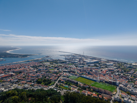 Aerial view of Viana do Castelo featuring the harbor urban rooftops green sports fields and the Atlantic Ocean coastline in Viana do Castelo Viana do Castelo Dist Portugal. Aerial view of Viana do Castelo featuring the harbor urban rooftops green sports fields and the Atlantic Ocean coastline in Viana do Castelo Viana do Castelo Dist Portugal.