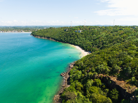 Aerial view of Jungle Beach with its turquoise waters and sandy cove surrounded by lush green hills in Unawatuna Sri Lanka. Aerial view of Jungle Beach with its turquoise waters and sandy cove surrounded by lush green hills in Unawatuna Sri Lanka.