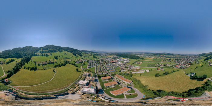 Aerial view of the town of Root featuring residential buildings construction sites and lush green hills under a clear blue sky Root Lucerne Switzerland. Aerial view of the town of Root featuring residential buildings construction sites and lush green hills under a clear blue sky Root Lucerne Switzerland.