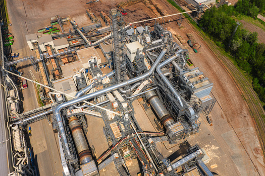 Aerial view of a large industrial wood processing facility with complex piping metal structures and conveyor belts in Jihlava Vysocina Region Czechia.