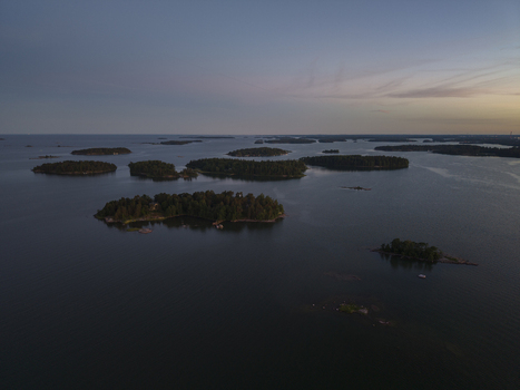 Aerial view of the Baltic Sea with numerous forested islands scattered across the calm water during the golden hour in Espoo Uusimaa Finland. Aerial view of the Baltic Sea with numerous forested islands scattered across the calm water during the golden hour in Espoo Uusimaa Finland.