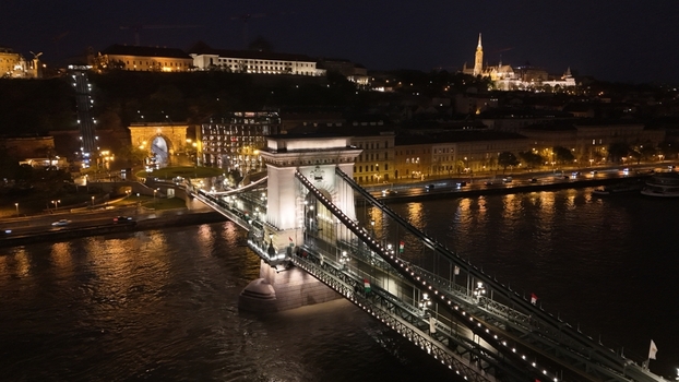 Aerial view of the illuminated Szechenyi Chain Bridge spanning the Danube river at night with the Buda Castle district in the background in Budapest Hungary. Aerial view of the illuminated Szechenyi Chain Bridge spanning the Danube river at night with the Buda Castle district in the background in Budapest Hungary.