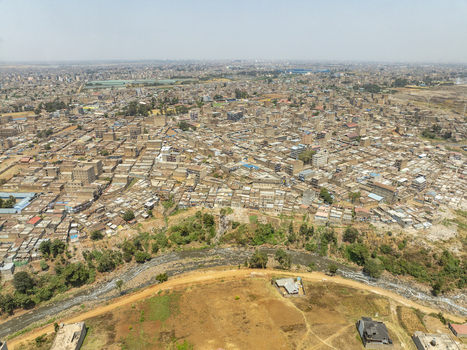 Aerial view of the Lucky Summer neighborhood in Nairobi featuring dense residential buildings a winding river and surrounding dry landscape in Nairobi Nairobi County Kenya. Aerial view of the Lucky Summer neighborhood in Nairobi featuring dense residential buildings a winding river and surrounding dry landscape in Nairobi Nairobi County Kenya.