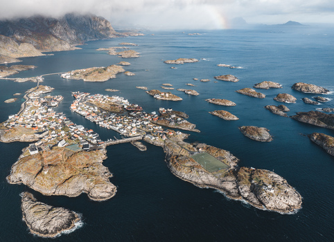 Aerial view of Lofoten islands featuring the coastal town of Leknes with colorful houses rocky terrain a soccer field on a small island and the surrounding sea in Leknes Nordland Norway. Aerial view of Lofoten islands featuring the coastal town of Leknes with colorful houses rocky terrain a soccer field on a small island and the surrounding sea in Leknes Nordland Norway.
