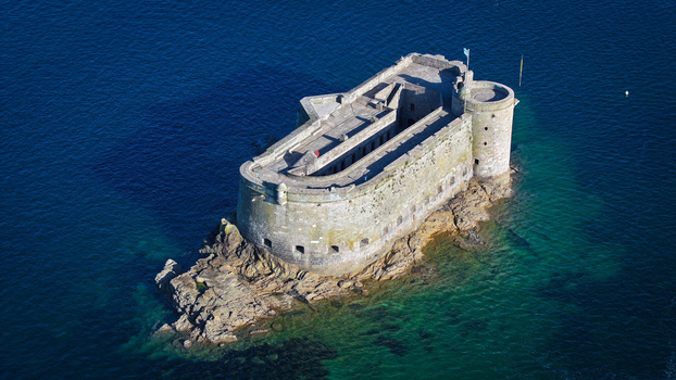 Aerial view of the imposing Fort du Taureau a stone sentinel rising from the sapphire sea its weathered walls echoing tales of maritime history Plouezoc h Bretagne France. Aerial view of the imposing Fort du Taureau a stone sentinel rising from the sapphire sea its weathered walls echoing tales of maritime history Plouezoc h Bretagne France.