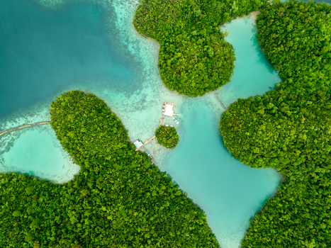Aerial view of Sugba Lagoon featuring turquoise waters lush green islands and a wooden dock in Del Carmen Caraga Philippines. Aerial view of Sugba Lagoon featuring turquoise waters lush green islands and a wooden dock in Del Carmen Caraga Philippines.