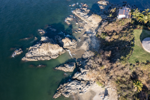 Aerial view of the rocky coastline of Sayulita with turquoise waters sandy beach and lush vegetation in Sayulita Nayarit Mexico. Aerial view of the rocky coastline of Sayulita with turquoise waters sandy beach and lush vegetation in Sayulita Nayarit Mexico.