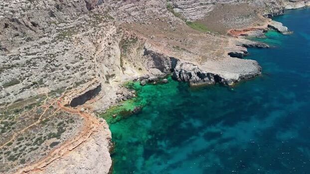 Aerial view of Ghar Lapsi Malta with rocky cliffs and turquoise bay water Aerial view of Ghar Lapsi Malta with rocky cliffs and turquoise bay water