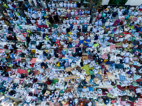Aerial view of a large gathering of people praying in neat rows their white clothing creating a serene pattern from above Charmonai Barisal Division Bangladesh. Aerial view of a large gathering of people praying in neat rows their white clothing creating a serene pattern from above Charmonai Barisal Division Bangladesh.