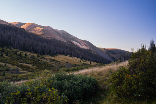 View of San Luis Peak at golden hour with rugged mountain slopes evergreen forests and alpine vegetation near the West Willow Creek Trailhead in Creede Colorado United States. View of San Luis Peak at golden hour with rugged mountain slopes evergreen forests and alpine vegetation near the West Willow Creek Trailhead in Creede Colorado United States.