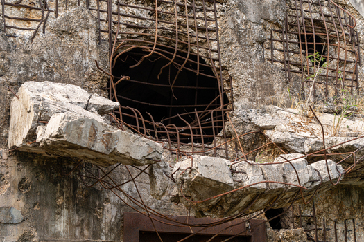 View of the damaged concrete ruins of the North Field Base with exposed rusted rebar and structural debris in Northern Tinian Tinian Northern Mariana Islands. View of the damaged concrete ruins of the North Field Base with exposed rusted rebar and structural debris in Northern Tinian Tinian Northern Mariana Islands.