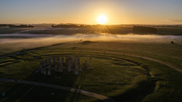 Aerial view of Stonehenge surrounded by misty fields at sunrise in Salisbury England United Kingdom. Aerial view of Stonehenge surrounded by misty fields at sunrise in Salisbury England United Kingdom.