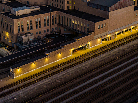 Aerial view of the illuminated platforms and tracks of Union Terminal casting a warm glow against the cool shadows of the surrounding architecture Cincinnati Ohio United States. Aerial view of the illuminated platforms and tracks of Union Terminal casting a warm glow against the cool shadows of the surrounding architecture Cincinnati Ohio United States.
