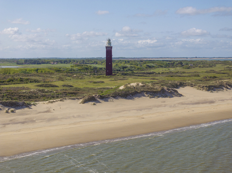 Aerial view of Westhoofd Lighthouse standing amidst sand dunes and green coastal landscape in Ouddorp Zuid Holland Netherlands. Aerial view of Westhoofd Lighthouse standing amidst sand dunes and green coastal landscape in Ouddorp Zuid Holland Netherlands.