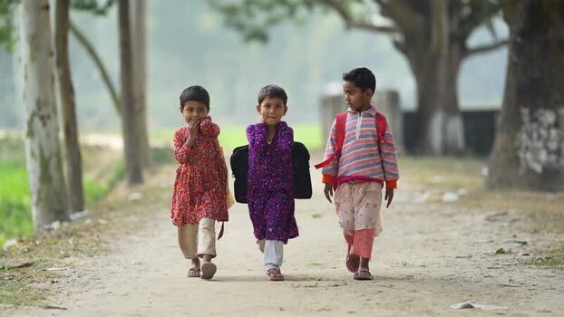 View of three children walking along a rural path Bangladesh.