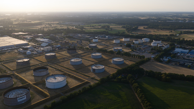Aerial view of Tanklager oil storage facility with large cylindrical tanks surrounded by green fields and trees in Hunxe North Rhine Westphalia Germany.