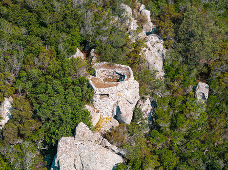 Aerial view of Passo del Monumento an ancient stone fortification nestled among dense Mediterranean scrub and rocky terrain in Campo nell Elba Toscana Italy.
