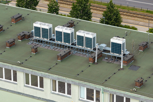 Aerial view of modern HVAC air conditioning units installed on a green flat rooftop of a building in Warsaw Masovian Voivodeship Poland. Aerial view of modern HVAC air conditioning units installed on a green flat rooftop of a building in Warsaw Masovian Voivodeship Poland.