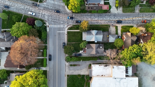 Aerial view of residential houses and lush green trees at a suburban street intersection with parked cars in Chicago Illinois United States. Aerial view of residential houses and lush green trees at a suburban street intersection with parked cars in Chicago Illinois United States.