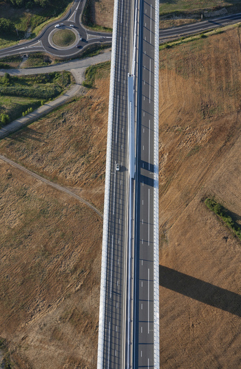 Aerial view of the soaring Millau Viaduct stretching across the golden fields a testament to engineering amidst the French landscape Millau France. Aerial view of the soaring Millau Viaduct stretching across the golden fields a testament to engineering amidst the French landscape Millau France.