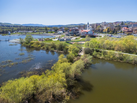 Aerial view of Oravska priehrada reservoir and the town buildings surrounded by lush green trees under a clear blue sky Namestovo Zilinsky kraj Slovakia. Aerial view of Oravska priehrada reservoir and the town buildings surrounded by lush green trees under a clear blue sky Namestovo Zilinsky kraj Slovakia.