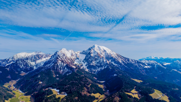 Aerial view of snow dusted mountains rising majestically over the valley the sky streaked with wispy clouds a scene of serene beauty Windischgarsten Upper Austria Austria. Aerial view of snow dusted mountains rising majestically over the valley the sky streaked with wispy clouds a scene of serene beauty Windischgarsten Upper Austria Austria.