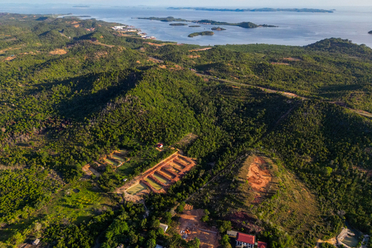 Aerial view of the lush tropical hills and coastal landscape of Galang Baru Island under a clear sky in Batam Riau Islands Indonesia.
