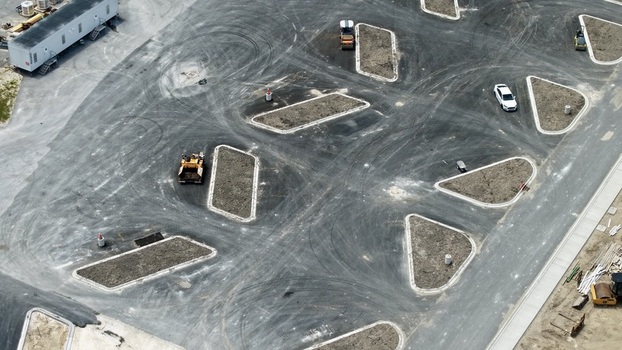 Aerial view of construction progress at Foundry Lane featuring heavy machinery and geometric road islands in World Golf Village Florida United States.