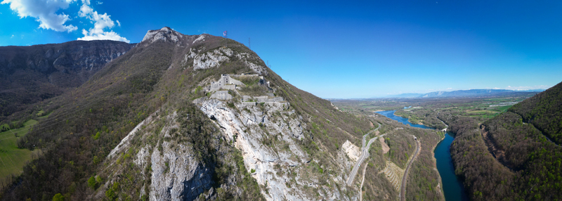 Aerial view of the stark white cliffs meet the verdant slopes overlooking the winding river and distant plains L&eacute;az Auvergne Rh&ocirc;ne Alpes France.