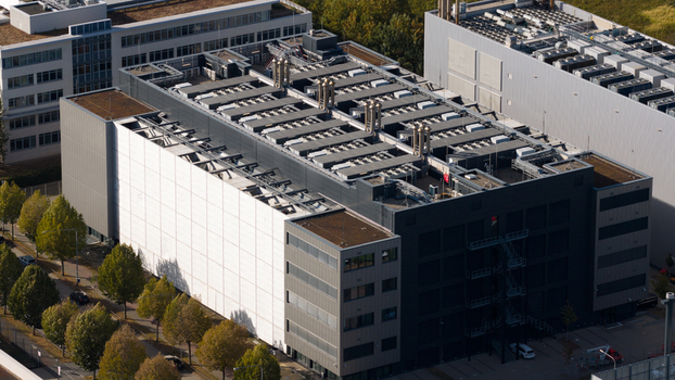 Aerial view of the Sossenheim datacenters featuring modern industrial architecture with large rooftop HVAC units and a prominent white facade section in Frankfurt am Main Hessen Germany. Aerial view of the Sossenheim datacenters featuring modern industrial architecture with large rooftop HVAC units and a prominent white facade section in Frankfurt am Main Hessen Germany.