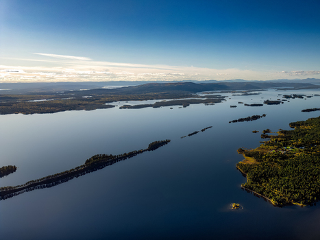 Aerial view of Galtispuoda mountain overlooking the vast calm lake system in Arjeplog with dense coniferous forests and scattered islands. Arjeplog Norrbotten County Sweden.