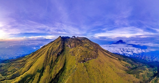 Aerial view of Mount Sumbing with its rugged peak and lush green slopes above a sea of clouds in Temanggung Central Java Indonesia. Aerial view of Mount Sumbing with its rugged peak and lush green slopes above a sea of clouds in Temanggung Central Java Indonesia.