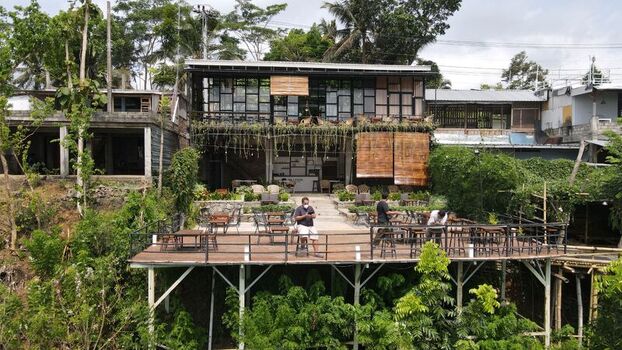 Gunungkidul Regency Indonesia 16 October 2021 Aerial view of an elevated outdoor cafe deck with wooden furniture and lush greenery in the Special Region of Yogyakarta. Gunungkidul Regency Indonesia 16 October 2021 Aerial view of an elevated outdoor cafe deck with wooden furniture and lush greenery in the Special Region of Yogyakarta.
