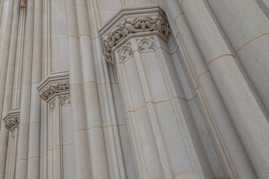 Washington District of Columbia United States 06 May 2025 View of intricate Gothic Revival stone columns and carved capitals on the exterior of the Washington National Cathedral.