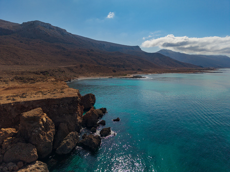 Aerial view of turquoise waters meeting rugged rocky cliffs under a vast sky where the land s warm hues contrast with the sea s cool depths Siqirah Socotra Yemen. Aerial view of turquoise waters meeting rugged rocky cliffs under a vast sky where the land s warm hues contrast with the sea s cool depths Siqirah Socotra Yemen.