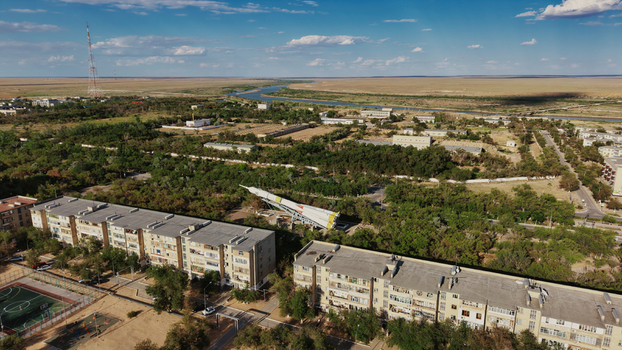 Aerial view of the Baikonur Cosmodrome rocket monument residential buildings and trees near a river in Karmakshy District Kyzylorda Region Kazakhstan.