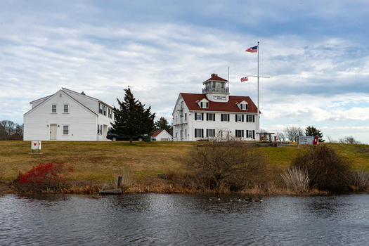 View of the historic white buildings of the Old Coast Guard Station with red roofs and an American flag on Martha s Vineyard in Edgartown Massachusetts United States.