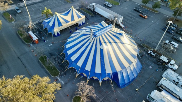 Aerial view of the vibrant blue and white striped circus tents standing boldly amidst the stark asphalt of the parking lot St. Augustine Florida United States. Aerial view of the vibrant blue and white striped circus tents standing boldly amidst the stark asphalt of the parking lot St. Augustine Florida United States.